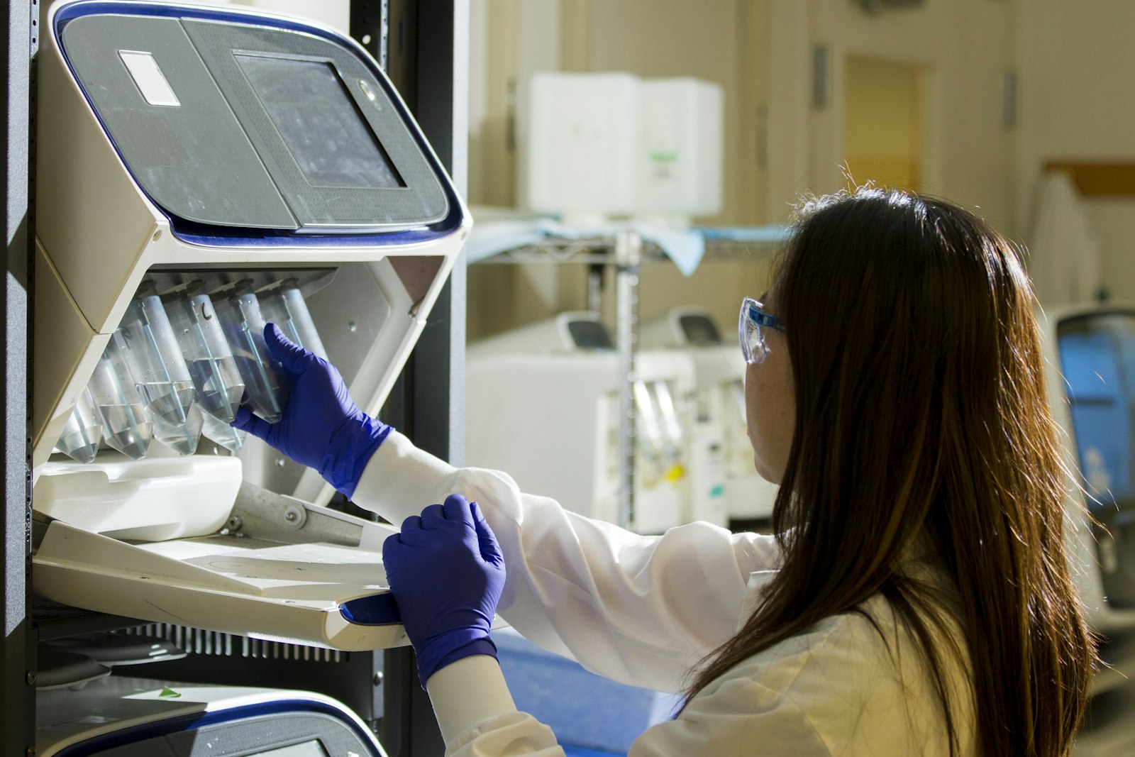 A researcher in gloves working at a laboratory bench